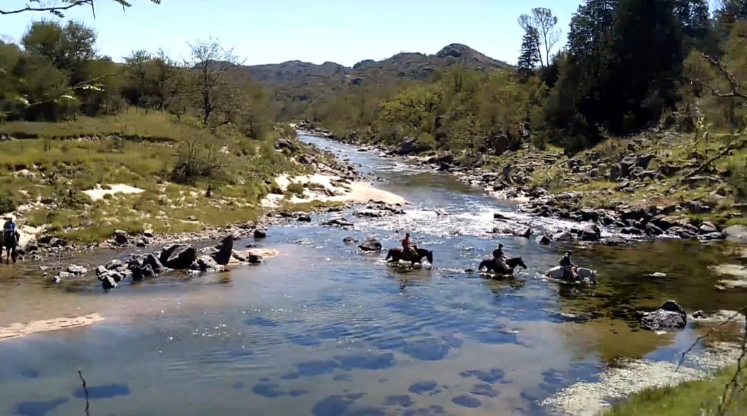 Jinetes cruzando el río en las sierras de Calamuchita